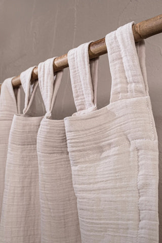 Cream tab loops on bamboo rod closeup. Handwoven 2-layer muslin cotton curtain, Denizli, OEKO-TEX. Vivamaison.