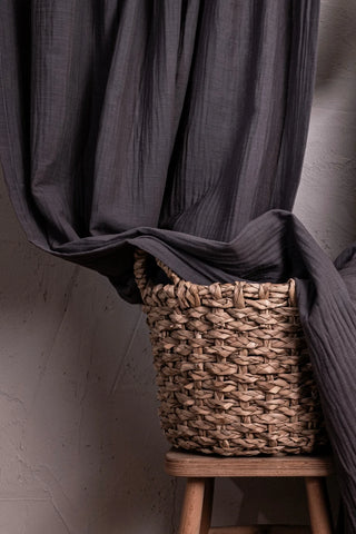 Gray muslin draped into basket on stool. Handwoven 2-layer muslin cotton curtain, Denizli, OEKO-TEX. Vivamaison.