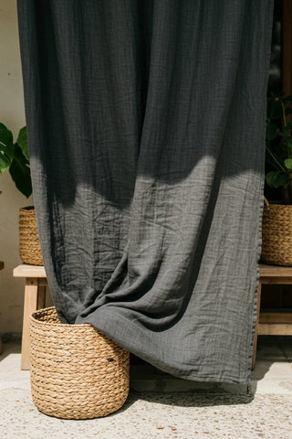 Gray panel draped into basket, outdoor patio. Handwoven 2-layer muslin cotton curtain, Denizli, OEKO-TEX. Vivamaison.