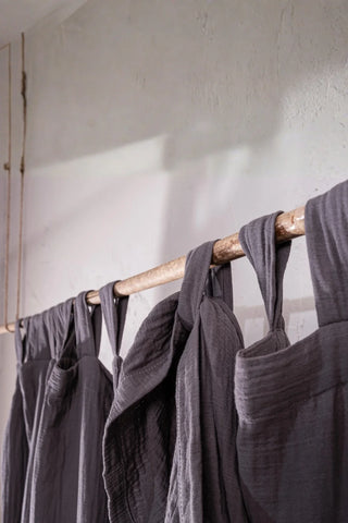 Gray tab loops on rustic rod closeup. Handwoven 2-layer muslin cotton curtain, Denizli, OEKO-TEX. Vivamaison.