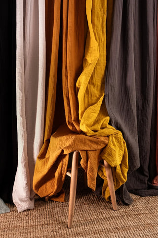 Rust yellow gray drapes styled over stool. Handwoven 2-layer muslin cotton curtain, Denizli, OEKO-TEX. Vivamaison.