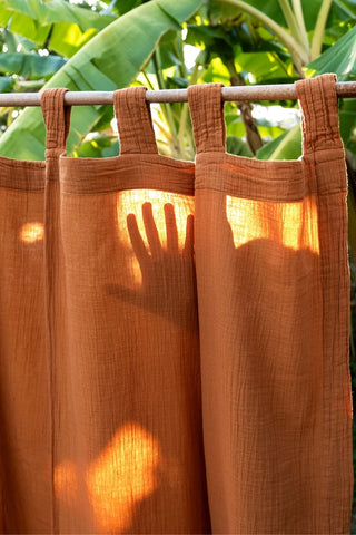 Terracotta tabs closeup, hand shadow silhouette. Handwoven 2-layer muslin cotton curtain, Denizli, OEKO-TEX. Vivamaison.