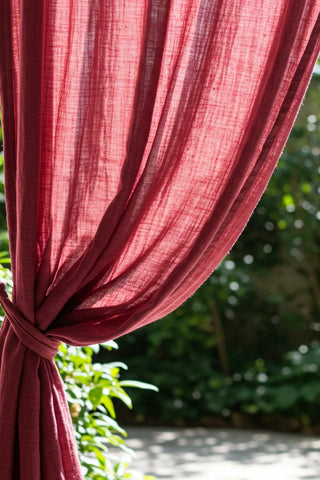 Backlit curtain gathered with tieback in garden. Handwoven 2-layer muslin cotton curtain, Denizli, OEKO-TEX. Vivamaison.