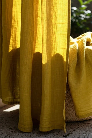 Mustard hem and weave closeup, backlit. Handwoven 2-layer muslin cotton curtain, Denizli, OEKO-TEX. Vivamaison.