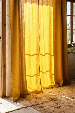 Sunlit mustard curtains beside rustic window. Handwoven 2-layer muslin cotton curtain, Denizli, OEKO-TEX. Vivamaison.