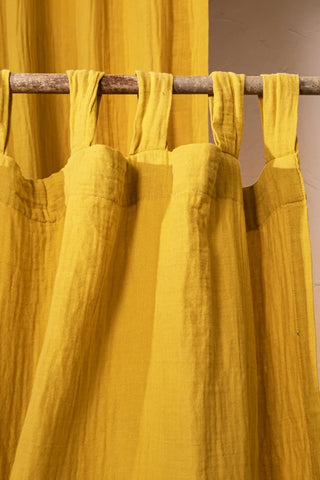 Mustard tab loops closeup on rustic rod. Handwoven 2-layer muslin cotton curtain, Denizli, OEKO-TEX. Vivamaison.