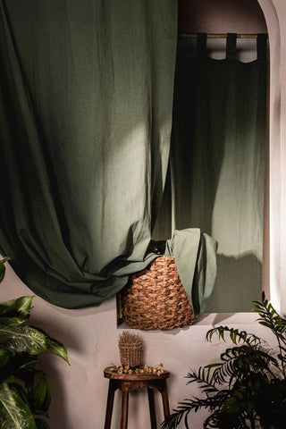 Dark green stonewashed cotton curtains draped by a niche window. Handwoven in Denizli, OEKO-TEX. Vivamaison.