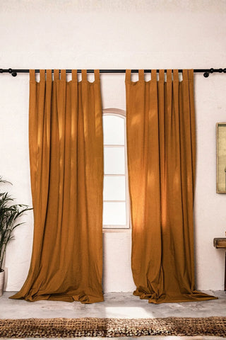 Terracotta stonewashed cotton curtain panels framing an arched window. Handwoven in Denizli, OEKO-TEX. Vivamaison.