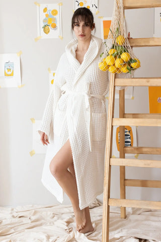 Handwoven waffle hooded bathrobe in white, front view with lemons. Turkish cotton Denizli, OEKO-TEX. Vivamaison.